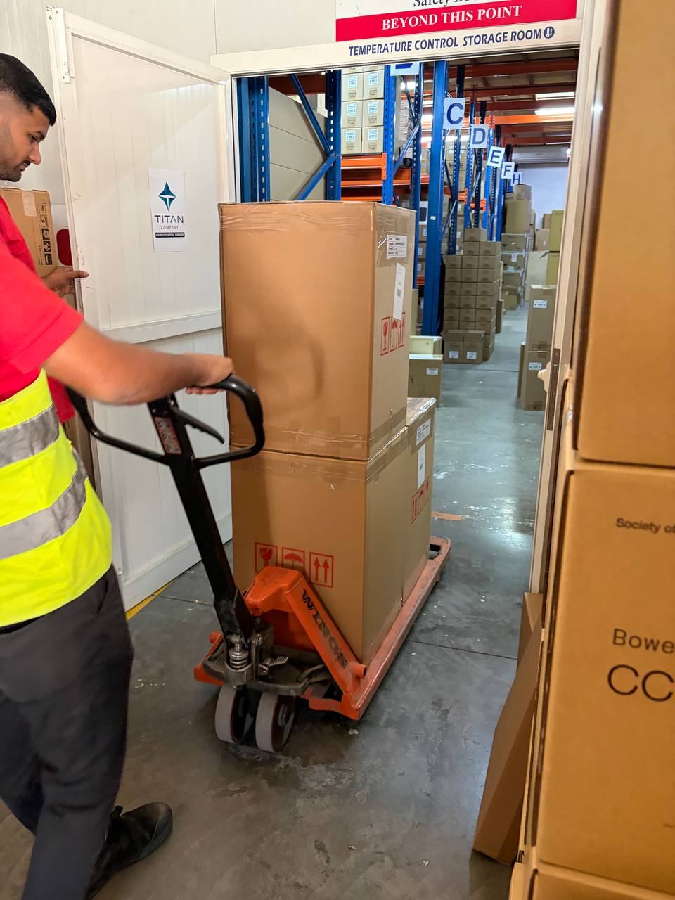 Warehouse team member moving cartons with a pallet jack