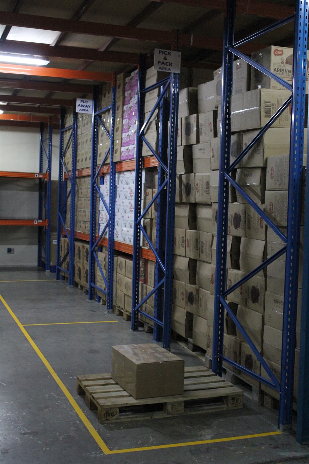 Palletised carton storage in a racking aisle